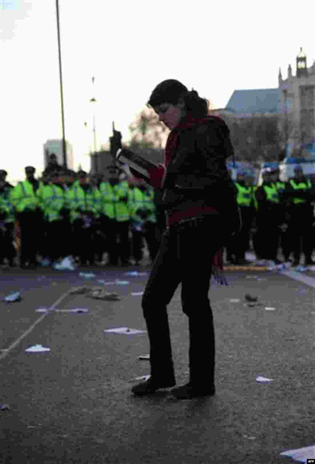 A lone protestor read a book in front of a line of police as thousands of student protest against tuition fees at Whitehall in London, Wednesday, Nov. 24, 2010. Thousands of British students protested Wednesday against government plans to triple tuition f