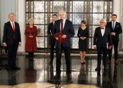 Jaroslaw Gowin, center, the head of a faction within the ruling conservative coalition, speaks to reporters about his proposal to postpone a presidential election in Poland by two years in Warsaw, Poland, April 3, 2020.