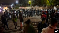 Supporters of presidential candidate Salvador Nasralla gather as police stand guard near the institute where election ballots are being recounted, as they protest what they call electoral fraud, in Tegucigalpa, Honduras, Dec. 1, 2017. 