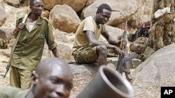 SPLM North rebels practice with a mortar as others watch along the border in South Kordofan, Sudan.