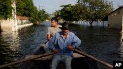 2015年12月23日巴拉圭首都地区水位大幅上涨 当地一位居民被迫以船代步。