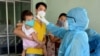 ဗီယက်နမ်နိုင်ငံ Da Nang မြို့မှာ ကိုယ်အပူချိန်တိုင်းတာပေးနေတဲ့ ကျန်းမာရေးဝန်ထမ်း။ (ဇူလိုင် ၂၆၊ ၂၀၂၀)