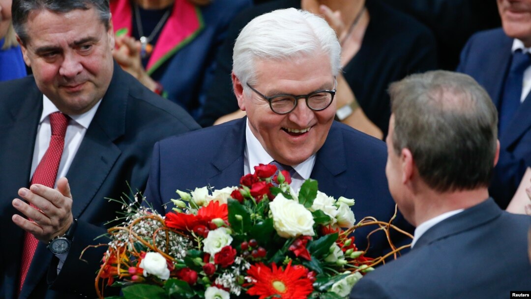 German president-elect, Frank-Walter Steinmeier, receives flowers after the first round of voting of the German presidential election at the Reichstag in Berlin, Feb. 12, 2017.