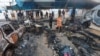 Palestinians survey the damage at the site of an Israeli strike on tents sheltering displaced people, amid the Israel-Hamas conflict, at Al-Aqsa Martyrs hospital in Deir Al-Balah in the central Gaza Strip, October 14, 2024. 