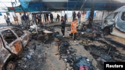 Palestinians survey the damage at the site of an Israeli strike on tents sheltering displaced people, amid the Israel-Hamas conflict, at Al-Aqsa Martyrs hospital in Deir Al-Balah in the central Gaza Strip, October 14, 2024. 