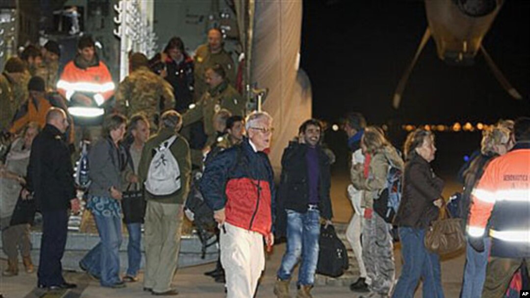 Evacuees from Libya step out of an Italian Air Force C-130 military plane at Rome's Pratica di Mare military airport, February 24, 2011