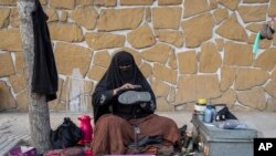 Seorang perempuan Afghanistan tampak membersihkan sepatu milik pelanggannya di sebuah jalanan di Kabul, Afghanistan, pada 5 Maret 2023. (Foto: AP/Ebrahim Noroozi)