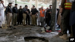 Police officers examine the site of bomb explosion in an Islamic seminary in Peshawar, Pakistan, Oct. 27, 2020. 