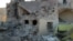 This photo provided by the Shafak Charity Organization, which has been authenticated based on its contents and other AP reporting, shows shows the badly damaged exterior of a medical facility dedicated to women after it was hit by four airstrikes that also killed two civilians in northern Idlib province, Syria, Nov. 25, 2016.