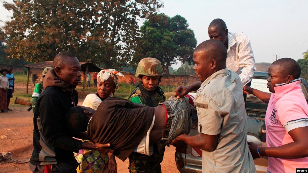 A man wounded in overnight clashes is assisted by peacekeepers and family members in a neighborhood in Bangui, Central African Republic, Dec. 23, 2013. 
