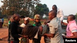 A man wounded in overnight clashes is assisted by peacekeepers and family members in a neighborhood in Bangui, Central African Republic, Dec. 23, 2013. 