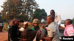 A man wounded in overnight clashes is assisted by peacekeepers and family members in a neighborhood in Bangui, Central African Republic, Dec. 23, 2013. 
