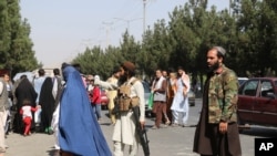 Taliban fighters stand guard outside the airport after Thursday's deadly attacks outside the airport in Kabul, Afghanistan, Aug. 27, 2021.