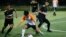 In this July 15, 2018, photo, Wild Boars soccer team, in black, play a local team during a Mae Sai league match in Mae Sai district in Chiang Rai province, northern Thailand. 