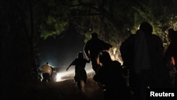 FILE - Families walk to turn themselves in to the U.S. Border Patrol after crossing the Rio Grande River into the United States from Mexico, in Roma, Texas, April 27, 2021. 