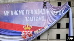 Ilustracija - postavljanje platna sa natpisom "Mi nismo genocidan narod" neposredno pre glasanja o Rezoluciji o genocidu u Srebrenici u UN (foto: OLIVER BUNIC / AFP)