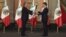 Outgoing leader Felipe Calderon (L) hands the national flag to Mexico's new president, Enrique Pena Nieto, during a midnight ceremony at the National Palace in Mexico City, Dec. 1, 2012. 
