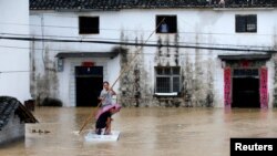  중국 안후이성 황산시에 집중호우가 내린 후 주민들이 지난 6일 임시 뗏목을 이용해 대피하고 있다. 
