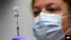 FILE - In this March 2, 2021, file photo, pharmacy technician Hollie Maloney loads a syringe with Pfizer's COVID-19 vaccine at the Portland Expo in Portland, Maine. The U.S. gave full approval to Pfizer's COVID-19 vaccine on Monday, Aug. 23, 2021. (AP Photo/Robert F. Bukaty, File