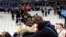 Fans comfort each other after descending onto the playing field in Stade de France stadium at the end of the friendly soccer match between France and Germany in Saint Denis, outside Paris, Nov. 13, 2015, the night of the terror attacks.