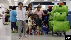 FILE - Passengers wait in line for a flight departing to Cuba at Miami International Airport in Miami, Florida, Sept. 27, 2012.