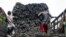 FILE - Somali porters offload charcoal from a truck at a charcoal market in Mogadishu, Oct. 30, 2012.