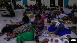 Voters gather and rest on the floor at the end of the voting day in a polling station at the Reverend Kim School in Kinshasa, Congo, on Dec. 20, 2023.