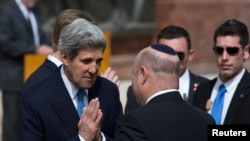 Menlu AS John Kerry (kiri) disambut oleh pejabat Israel sebelum meletakkan karangan bunga dalam peringatan Hari Holocaust Israel di Yad Vashem, Yerusalem (8/4).