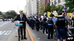 18 Ağustos 2024 - Illinois eyaletinin Chicago kentindeki United Center'da Demokrat Parti Ulusal Kurultayı (DNC) öncesinde üreme hakları, LGBTİ hakları ve Gazze'de ateşkes talebiyle düzenlenen protesto sırasında bir sıra polis memuru hazır bulundu.