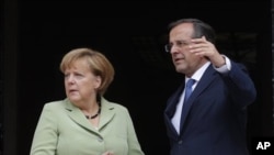 PM Yunani Antonis Samaras (kanan) saat menerima kunjungan Kanselir Jerman Angela Merkel di Athena (9/10). Perundingan Yunani dengan kreditor internasional masih macet. 