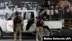 Police stand guard under an overpass in Port-au-Prince, Haiti, Monday, July 12, 2021.