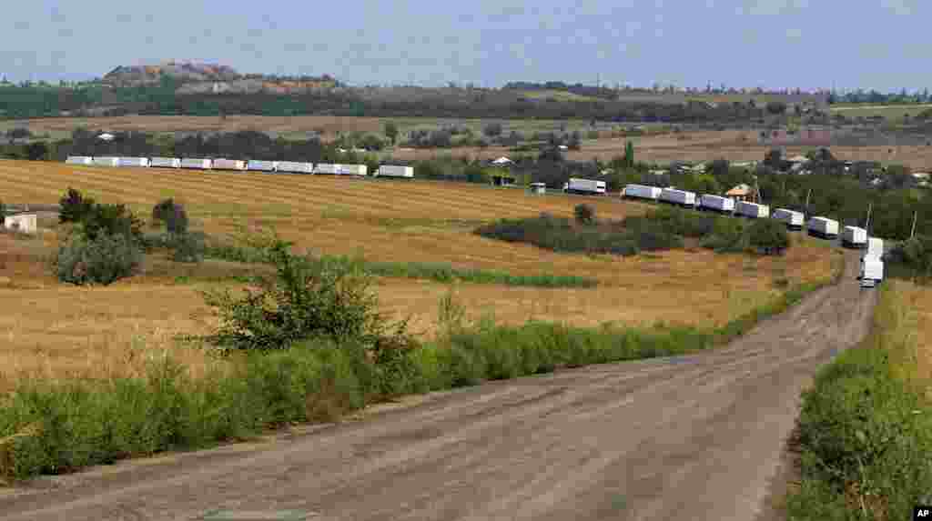 Convoy trucks move down the main road to Luhansk after passing through the Russia - Ukraine border post at Izvaryne, near the village of Uralo-Kavkaz, eastern Ukraine, Aug. 22, 2014.
