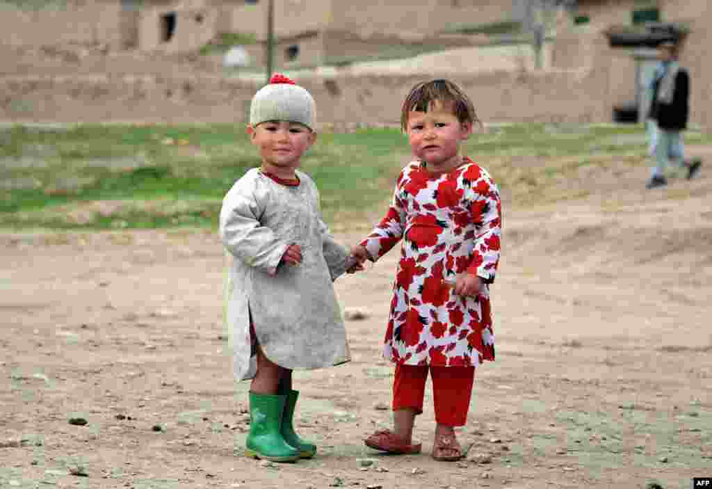 Afghan children look on as they walk in their neighborhood in the Kishindih district of northern Balkh Province.