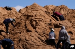 FILE - Artists work on a sand sculpture depicting a pharaoh and a pyramid, as part of Good Friday celebrations in Arenales de Cochiraya, on the outskirts of Oruro, Bolivia, Friday, April 7, 2023. (AP Photo/Juan Karita)