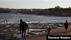 Families enjoy a clear evening on the coast in Sydney, Australia, on May 6, 2020.