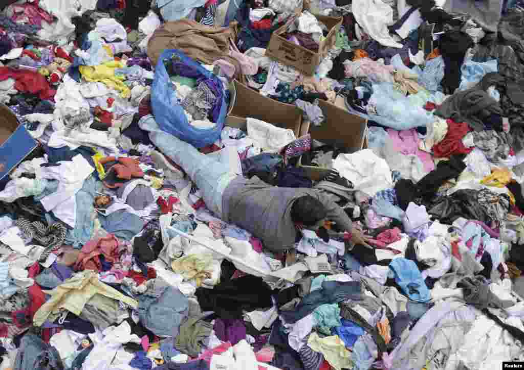 A migrant searches for clothes at Keleti railway station in Budapest, Hungary, Sept. 7, 2015.