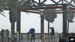 Warga terjebak dalam hujan lebat akibat Badai Tropis Colin di Pantai Clearwater, Clearwater, Florida (6/6).(AP/Chris O'Meara)