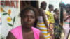 Ebola survivor Finda Fallah sits in front of her new room in West Point, Monrovia. (Benno Muchler/VOA)