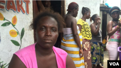 Ebola survivor Finda Fallah sits in front of her new room in West Point, Monrovia. (Benno Muchler/VOA)