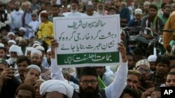 FILE - A Pakistani holds a placard that reads "Terrorists should be punished," during a protest to condemn a series of suicide bombings, in Karachi, Feb. 19, 2017. Sindh provincial counterterrorism authorities are concerned about a trend among educated youth resort to militancy and extremism.