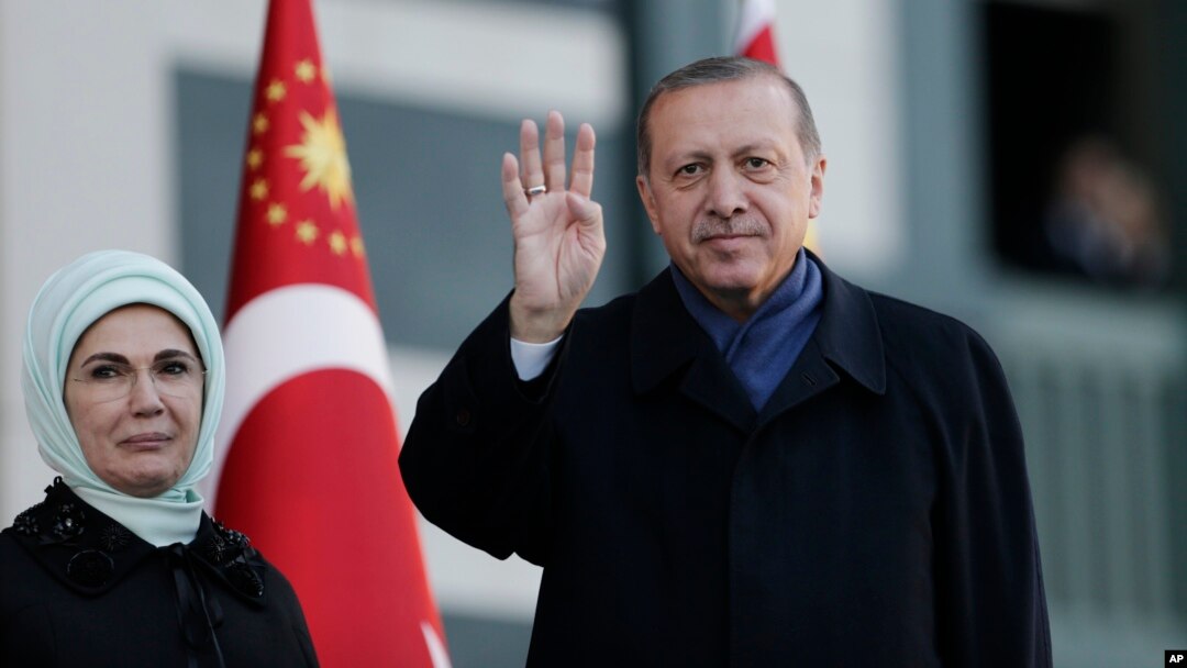 Presiden Turki Recep Tayyip Erdogan dan istrinya, Emine, melambai kepada pendukungnya di Ankara, Senin (17/4). 