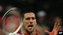 Novak Djokovic of Serbia returns a ball to Gilles Simon of France during their Davis Cup Final match in Belgrade, Serbia, Friday, Dec. 3, 2010.