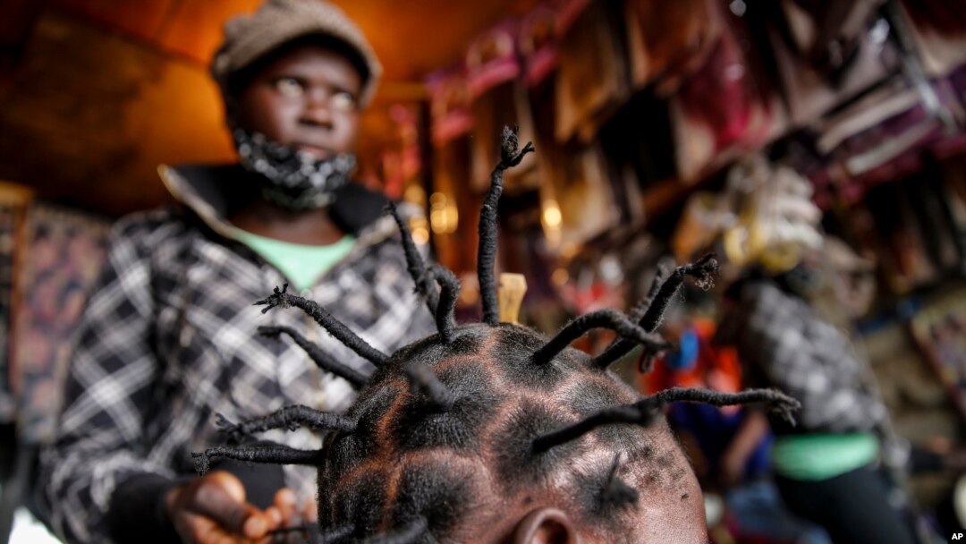 Gettrueth Ambio, 12, has her hair styled in the shape of the new coronavirus, at the Mama Brayo Beauty Salon in the Kibera slum, or informal settlement, of Nairobi, Kenya, Sunday, May 3, 2020.