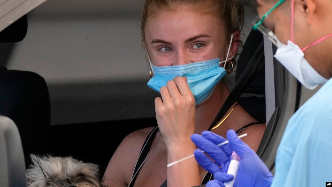 A woman has a swab taken at a drive-through COVID-19 testing clinic at Bondi Beach in Sydney, Dec. 21, 2021. 
