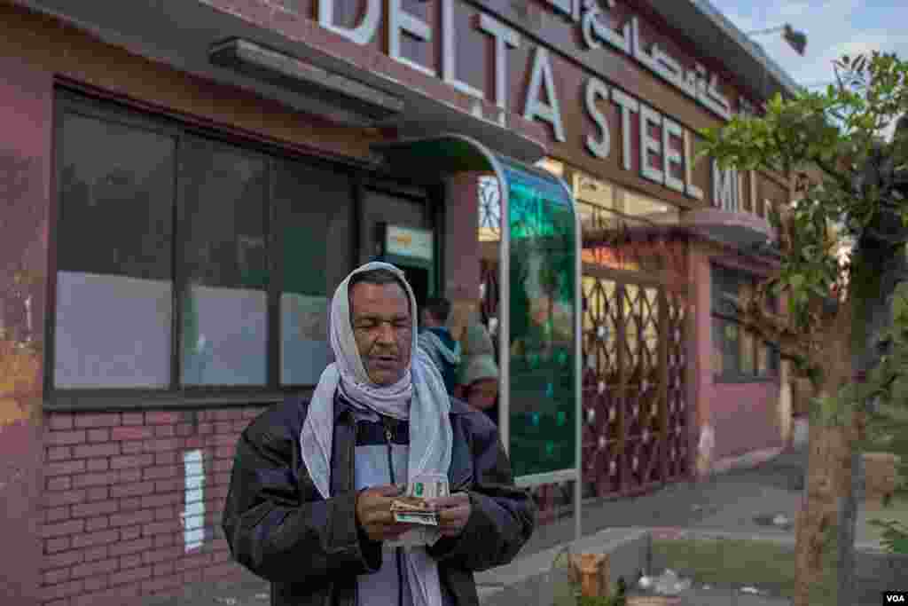 A retirement salary from Delta Steel Company helps Abdallah pay his bills. (Hamada Elrasam/VOA)