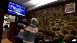 FILE - People have lunch as they await the televised last announcement of the Basque armed separatist group ETA in Hernani, Spain, on May 3, 2018. Four ETA members were sentenced on Dec. 12, 2024, to nearly 75 years each in prison for attempted murder.