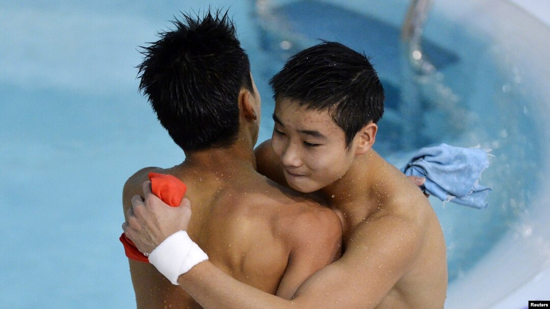 China's Cao Yuan (R) hugs his team mate Zhang Yanquan after their last dive in the men's synchronized 10m platform final during the London 2012 Olympic Games at the Aquatics Centre July 30, 2012. 