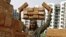  FILE - A laborer stacks bricks on his head at the construction site of a residential complex in Kolkata.