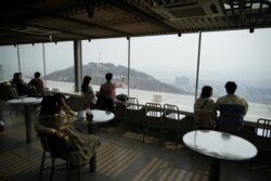 Couples enjoy the view while practicing social distancing during the global spread of the coronavirus disease (COVID-19), at an observatory near "N Seoul Tower" located atop Mt. Namsan in Seoul, South Korea, April 7, 2020.