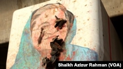 FILE - A mural of Bangladesh's ousted Prime Minister Sheikh Hasina is posted on a pillar with a garland of shoes hanging on it, in Dhaka, Bangladesh, Sept. 28, 2024. 